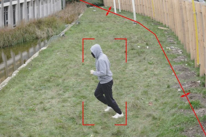 Imagem real de videomonitoramento com linha virtual de detecção, setas de cruzamento e pessoa dentro da zona protegida